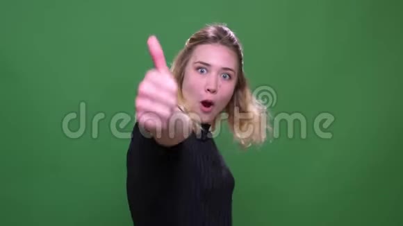 年轻漂亮的白种人女性的特写照片她竖起大拇指开心地看着背景的照相机视频的预览图