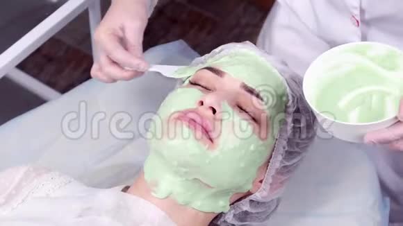 美与美容理念一位在美容院戴着奶油面具的年轻女子视频的预览图
