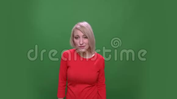 中年金发短发模特在绿色的彩色背景上积极而奇怪地孤立地跳舞视频的预览图
