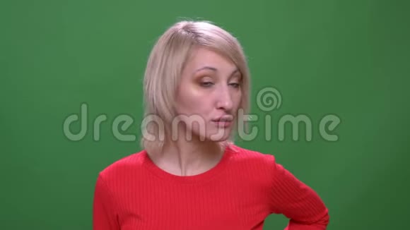 中年金发短发女人调情的镜头显示她的嘴唇孤立在绿色的色彩背景视频的预览图