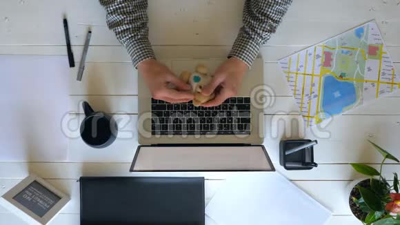男人拿着他最喜欢的软玩具玩男性商人用木制手提电脑键盘打字视频的预览图