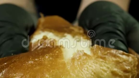 关闭面包师男子手撕裂热面包隔离在黑色背景库存录像用黑手套煮公手视频的预览图