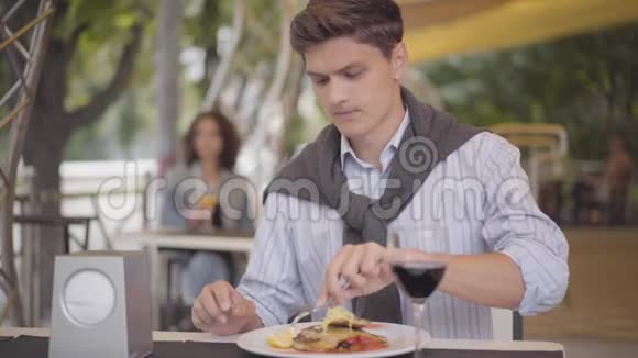 年轻人在街头咖啡馆吃美味的肉喝红酒那个女孩在户外享受他的晚餐放松这就是视频的预览图