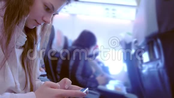 女人在飞机上玩手机游戏视频的预览图