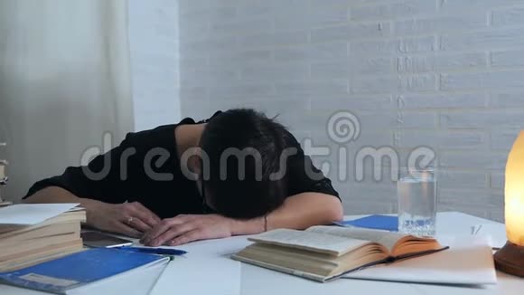 一位女诗人用铅笔在纸上写笔记疲劳时在桌旁睡着了但一个电话把她吵醒了视频的预览图