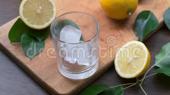 人手把柠檬汁从水罐里倒入装有冰块的杯子里快关门视频的预览图