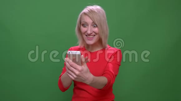 中年短发女商人在视频电话上谈论智能手机孤立于绿色的背景视频的预览图