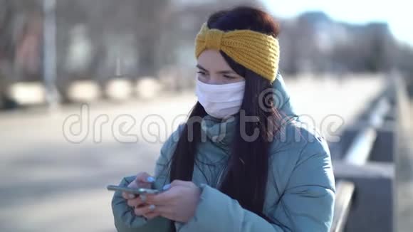 戴着面具在智能手机上发短信的年轻女子视频的预览图