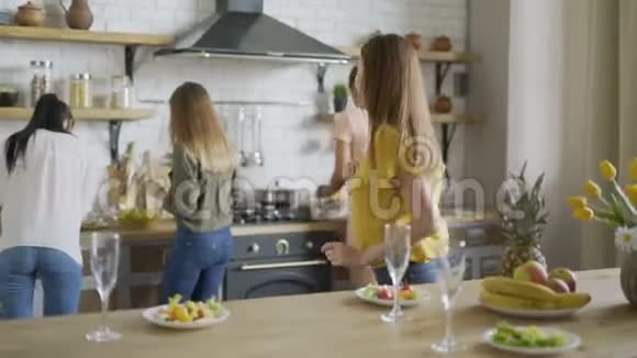 女孩们让吃吧5个年轻活跃的女朋友做沙拉并准备晚餐把盘子放在桌子上欢笑与欢笑视频的预览图