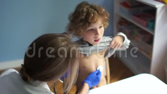 儿科医生用听诊器听孩子的肺男孩咳嗽蓝手套国际医生天视频的预览图