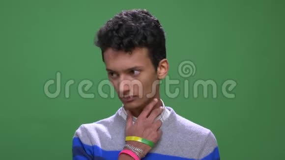 印度年轻有魅力男性的特写镜头喉咙不适背景与绿色隔离视频的预览图