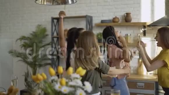 现场直播5个迷人的少女在厨房里玩在电话4K上拍摄视频视频的预览图
