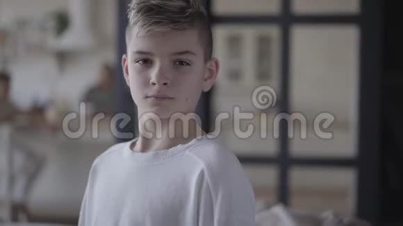 一个小男孩在镜头下近距离观看的肖像穿着白色t恤的没感情的男孩真正的人视频的预览图