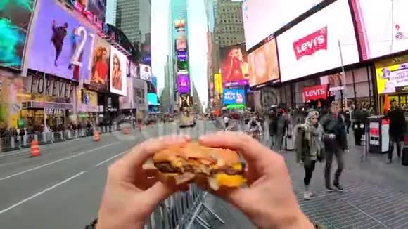年轻人在时代广场吃汉堡包的时间视频的预览图