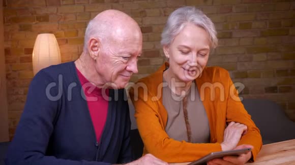高白种人夫妇聚精会神地看着平板电脑坐在家里视频的预览图