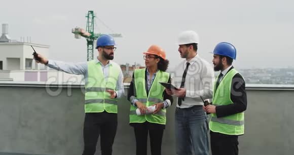 一群建筑工地的多民族工人工程师建筑师和工头分析施工计划视频的预览图