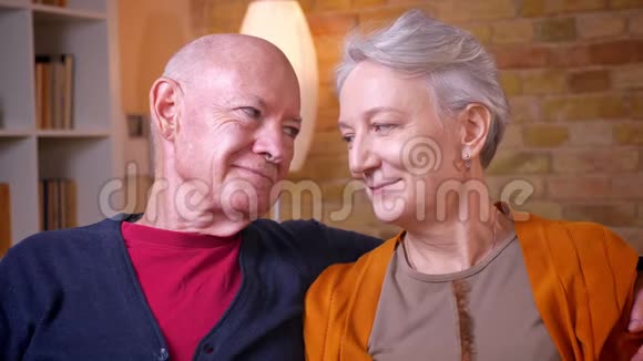 高白种人夫妇的特写镜头坐在沙发上在家温柔地看着对方视频的预览图