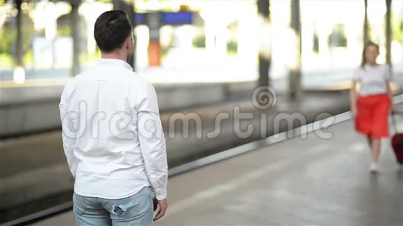 火车站情侣的慢动作视图英俊的男朋友在长途旅行后会见了她的女朋友视频的预览图