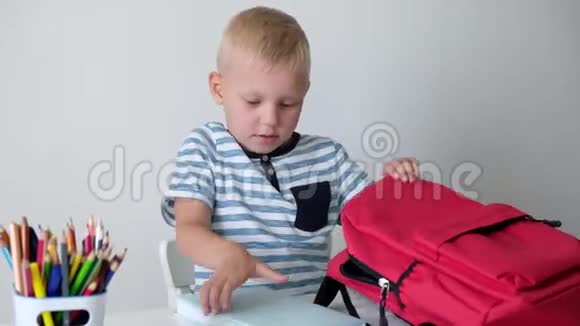 回学校去可爱的小男孩把书放进包里小学的孩子视频的预览图
