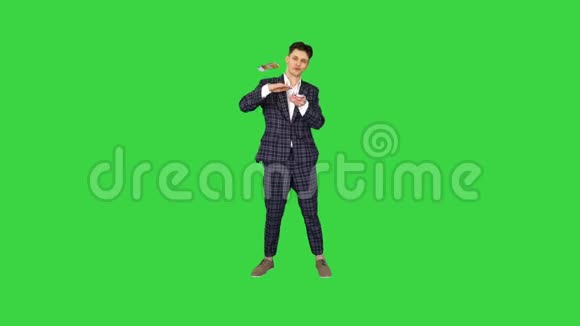 年轻快乐的商人跳舞把钱扔在绿色屏幕上Chroma键视频的预览图
