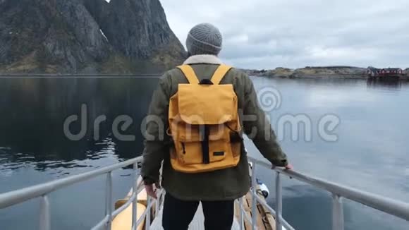 旅行者去码头穿着夹克和针织帽子和黄色背包后景挪威抢劫视频的预览图