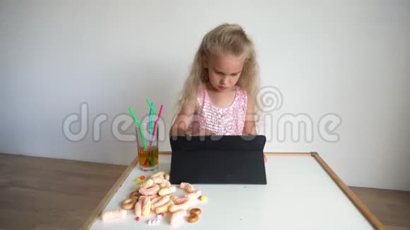 四岁的金发小孩在看平板电脑快乐的电脑迷妹视频的预览图