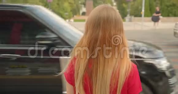 特写后景照片年轻的金发女郎长发美女站在户外的路边视频的预览图