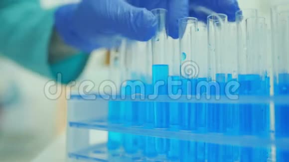 实验室里的一位医生或科学家正在用蓝色液体放置试管疫苗和病毒的概念视频的预览图