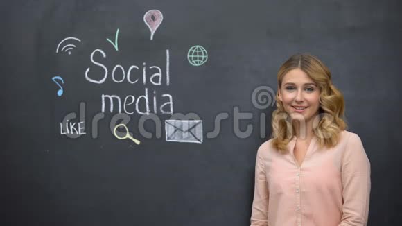 女孩指着黑板上的社交媒体标志沉迷于网络视频的预览图