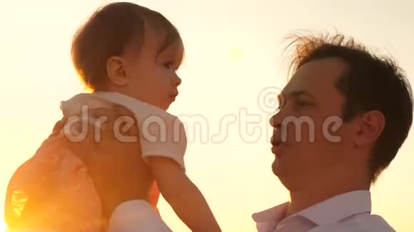 爸爸和他心爱的女儿玩耍这是他父亲怀里一个孩子爸爸在日落时亲吻公园里的一个小孩子快乐视频的预览图