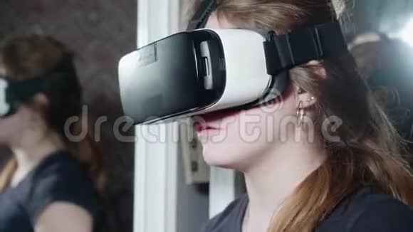 穿着黑色t恤戴着耳机的VR眼镜的女孩环顾四周视频的预览图