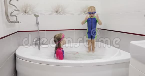 穿泳衣的弟弟妹妹正在浴室里玩得很开心视频的预览图