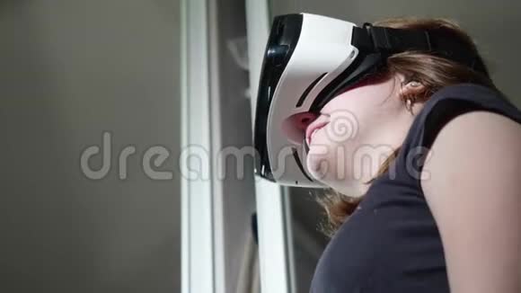下观白种人女孩戴着黑色t恤的VR眼镜视频的预览图