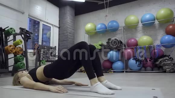 女人在不同的库存背景下在垫子上做锻炼视频的预览图