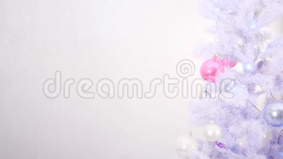 用白色银色和粉红色装饰的圣诞树在白色背景上闪耀着花环视频的预览图