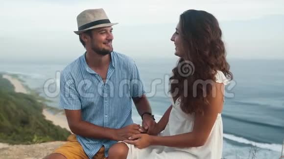 情侣们坐在浪漫的地方双手并拢慢动作视频的预览图