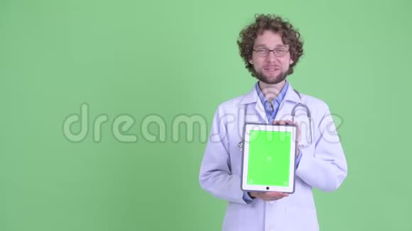 一位年轻有胡子的医生正在展示数码平板电脑视频的预览图