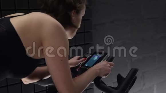 这个视频是关于背面的观点漂亮的年轻女子享受她的锻炼自行车与电脑你真漂亮视频的预览图