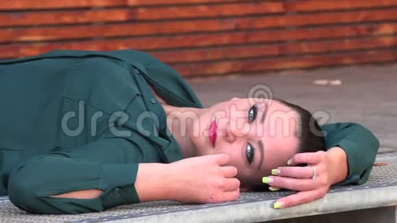 穿绿色衬衫的女孩躺着牛仔裤视频的预览图