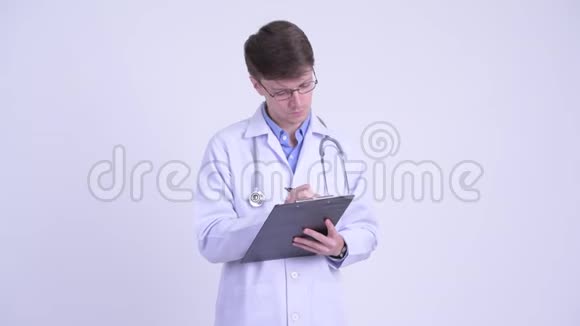 年轻英俊的医生在剪贴板上咨询和书写视频的预览图