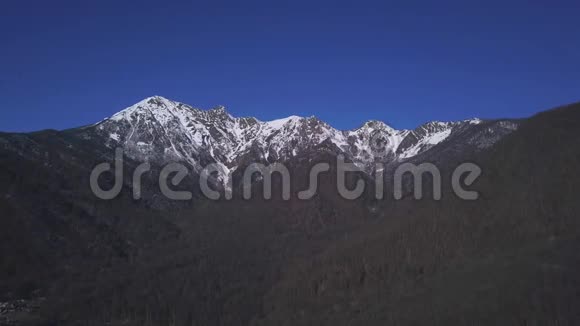 风景秀丽的蓝天背景上的雪山剪辑冬季高岩景观空中视频的预览图