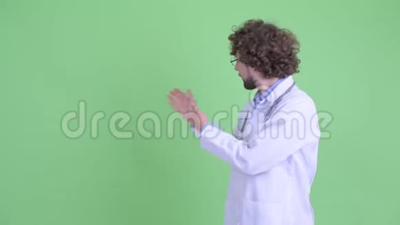 快乐的小胡子男医生在后面展示一些东西并得到好消息视频的预览图