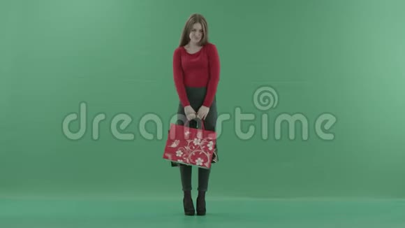 漂亮尴尬的女人穿着休闲服摆着购物袋她站在一间工作室里反对视频的预览图