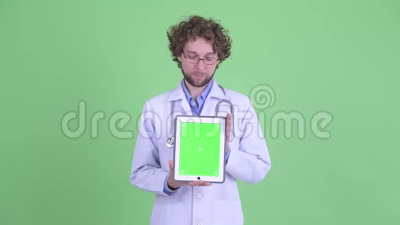 一位满脸胡须的年轻医生展示了数码平板电脑视频的预览图