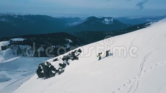 穿着滑雪板和滑雪设备在高山上攀爬的空中射击背包客视频的预览图