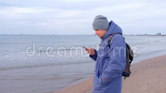 冬天人类正在沿海小镇的智能手机上输入信息侧视视频的预览图