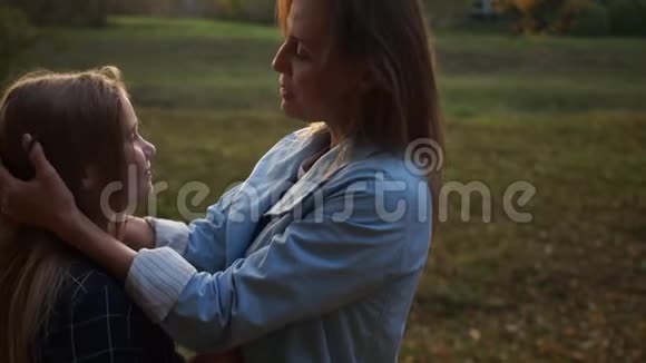 母亲节后景动态视频晚上拥抱的母亲和女儿的近距离户外肖像视频的预览图