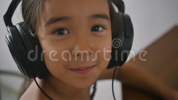 戴着耳机的可爱小女孩的肖像慢动作视频的预览图