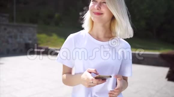 街上一个微笑的女孩的肖像使用智能手机视频的预览图