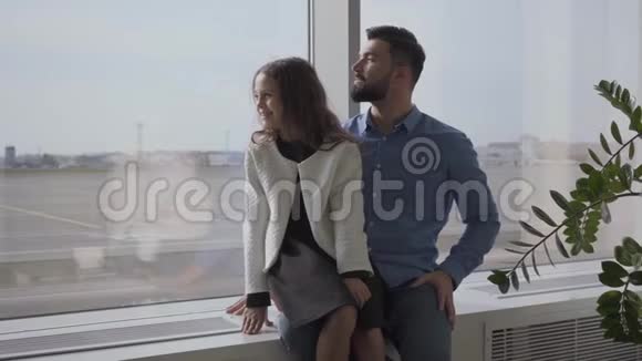 快乐的白种人父亲和女儿坐在机场窗台上看着跑道小可爱视频的预览图
